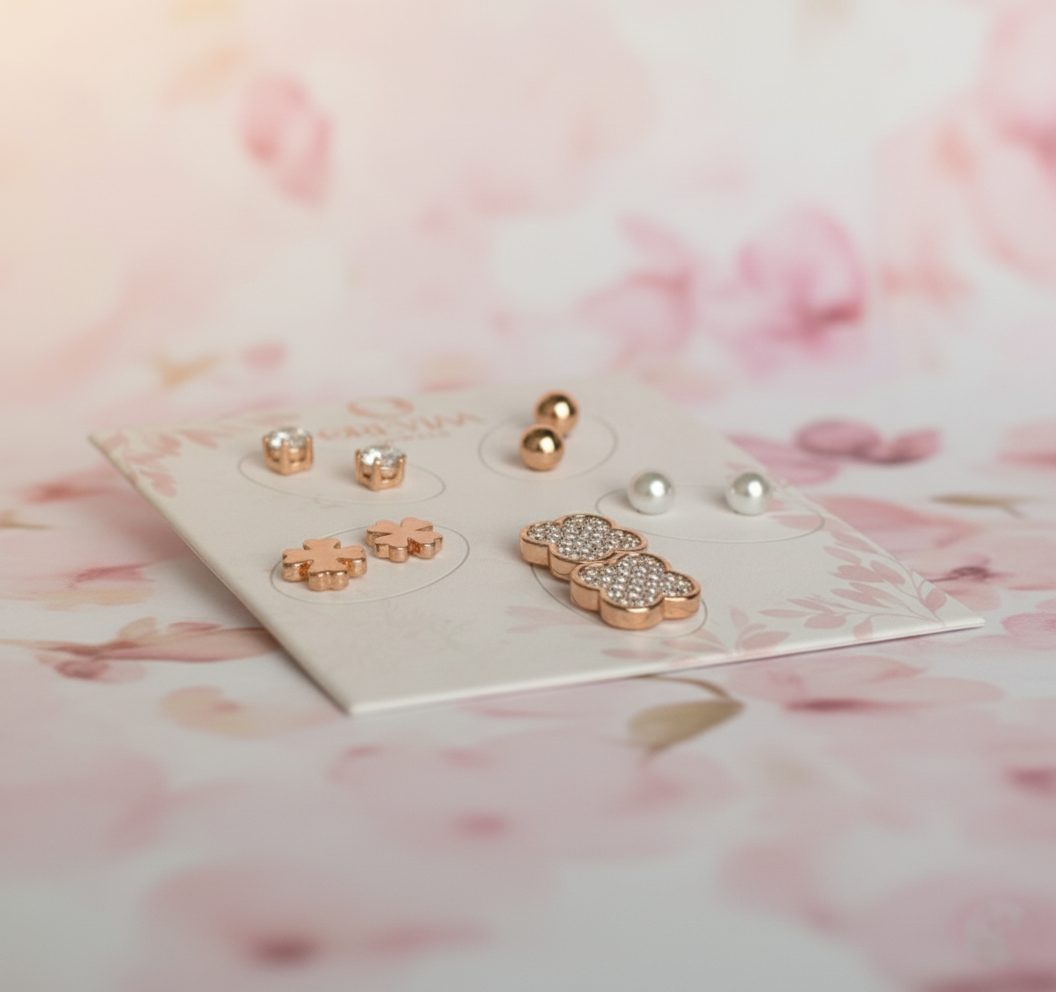 Set of earrings on a display card with a soft pink floral background
